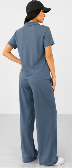 Woman wearing a blue outfit with wide-leg pants and a black cap on a white background