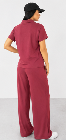 Person wearing a maroon outfit with a cap on a white background