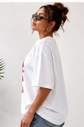 Woman wearing a white t-shirt with a graphic design on a plain background