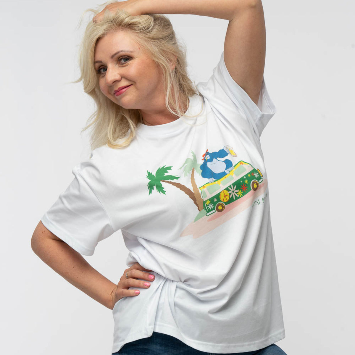 Woman wearing a white t-shirt with a colorful graphic design on a plain background