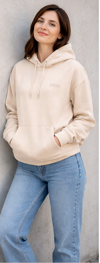 Person wearing a beige hoodie with  blue jeans casual outfit