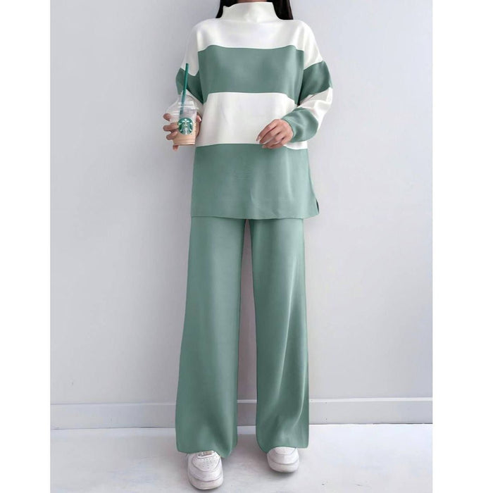 Person wearing a green and white striped outfit with wide-leg pants, holding a Starbucks cup.