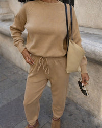 Person wearing a beige outfit with a matching bag in an urban setting