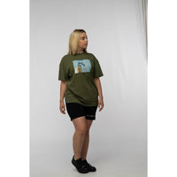 Person wearing an olive green t-shirt with a graphic design on a plain background