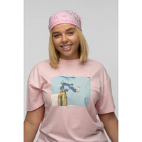 Person wearing a pink t-shirt with a graphic design and matching pink bandana.